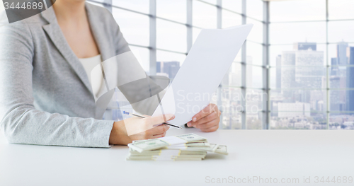 Image of close up of female hands with money and tax report