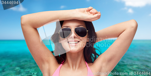 Image of happy woman in sunglasses and swimsuit