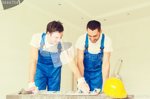 Image of group of builders with blueprint