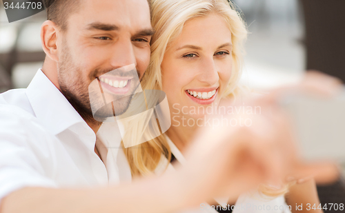 Image of happy couple taking selfie with smatphone outdoors