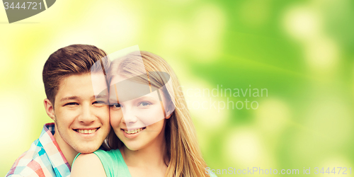 Image of smiling couple hugging over green background