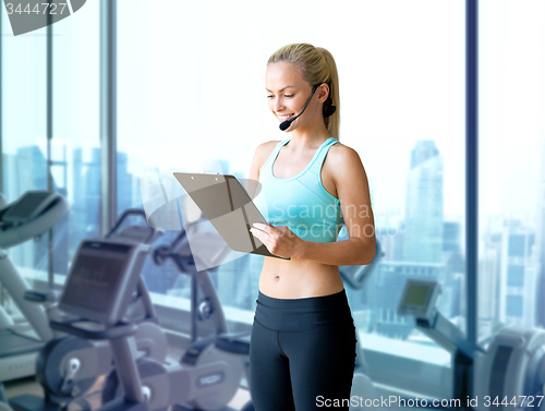 Image of happy woman trainer with microphone and clipboard