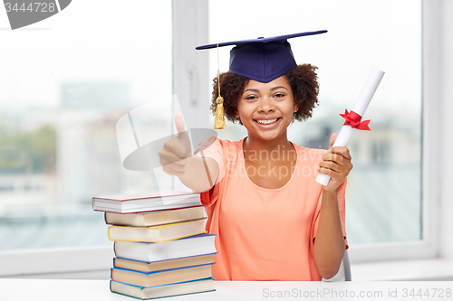 Image of happy african bachelor girl with books and diploma