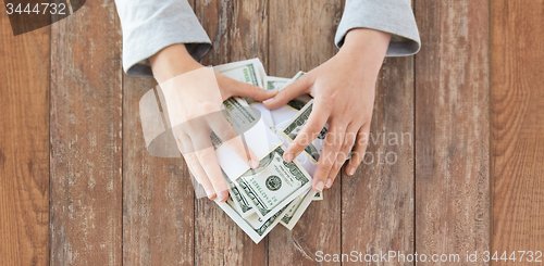 Image of close up of woman hands counting us dollar money