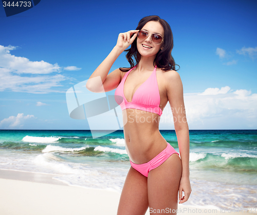 Image of happy woman in sunglasses and bikini swimsuit