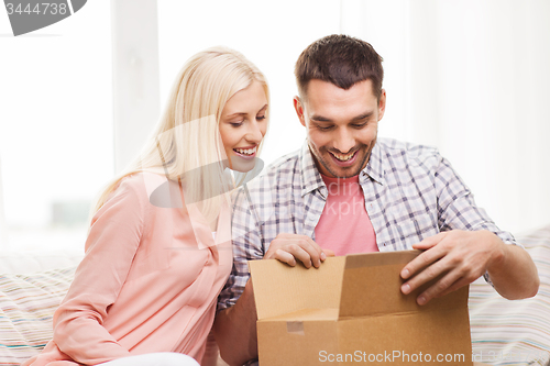 Image of happy couple with parcel box at home