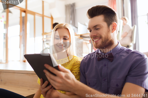 Image of happy creative team with tablet pc in office