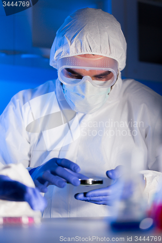 Image of close up of male scientist with test sample in lab