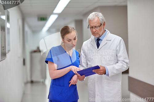 Image of senior doctor and nurse with tablet pc at hospital