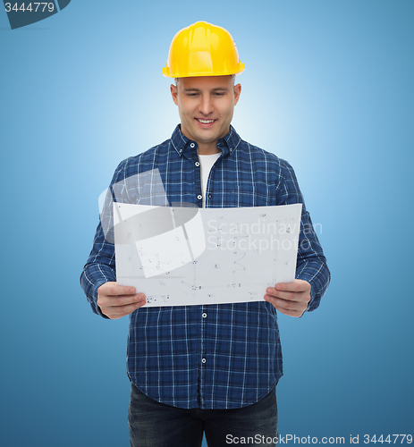 Image of smiling male builder in helmet with blueprint