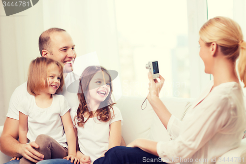 Image of mother taking picture of father and daughters