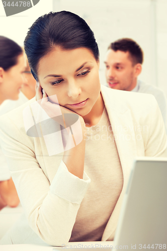 Image of businesswoman with laptop computer at work