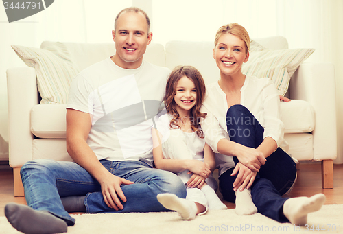 Image of parents and little girl sitting on floor at home