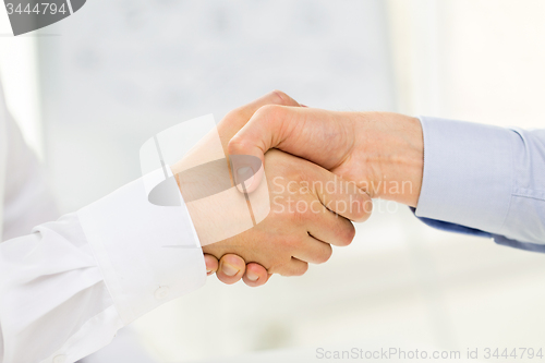Image of close up of hands making handshake in office