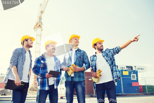 Image of group of smiling builders with tablet pc outdoors