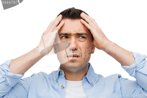 Image of unhappy man with closed eyes touching his forehead