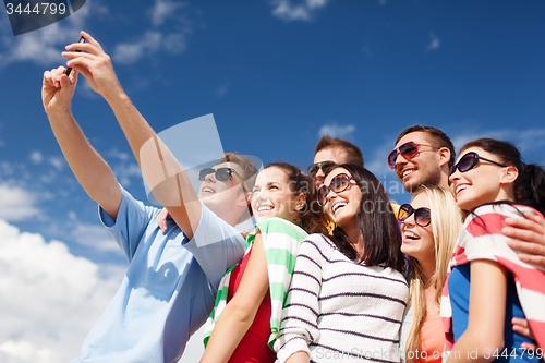 Image of group of friends taking selfie with cell phone