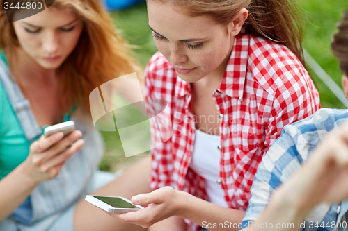 Image of friends with smartphone at camping