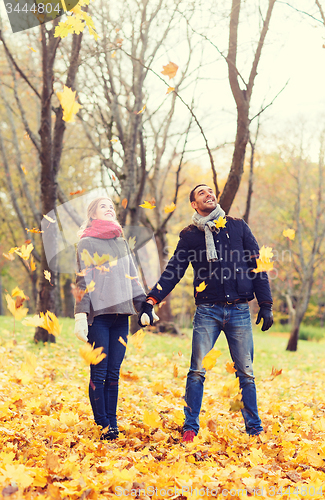 Image of smiling couple having fun in autumn park