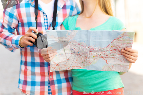 Image of close up of couple with map and camera in city