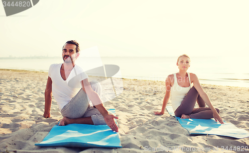 Image of couple making yoga exercises outdoors