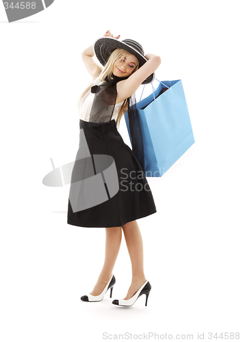 Image of blond in retro hat with blue shopping bag