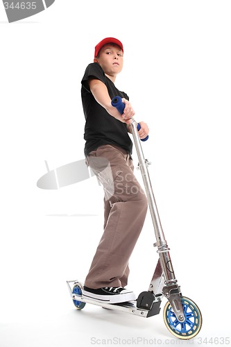 Image of Boy standing on a scooter