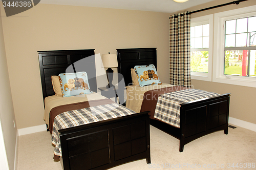 Image of Bedroom with two single beds and windows.