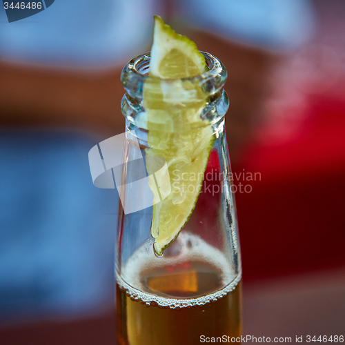Image of ice cold beer in a bottle with wedge lime