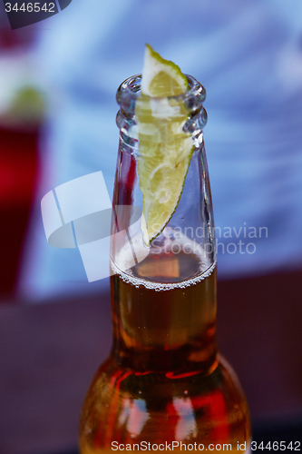 Image of ice cold beer in a bottle with wedge lime