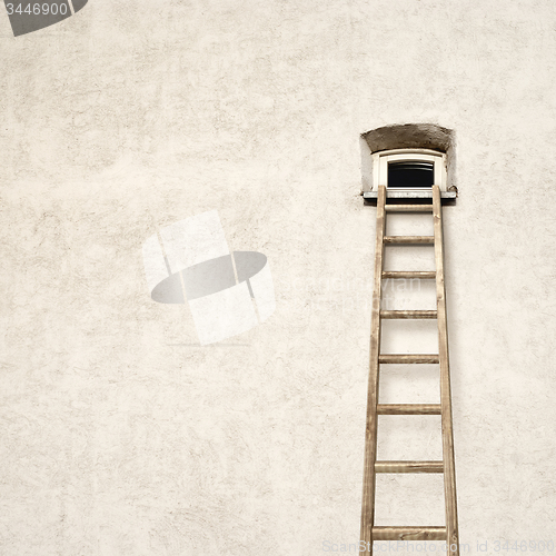 Image of wall with a small window and wooden ladder