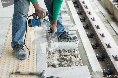 Image of Worker breaking concrete