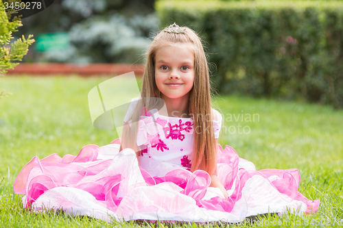 Image of Girl princess sat on the lawn in the green garden