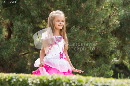 Image of Girl in dress walking in the garden