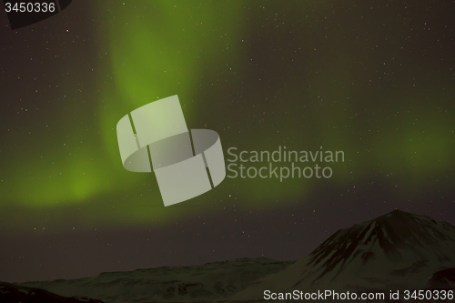 Image of Northern lights with snowy mountains in the foreground