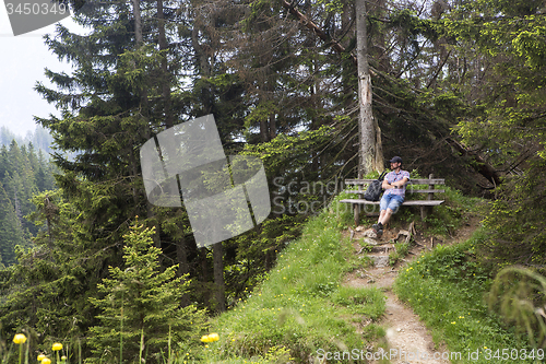 Image of Hiker takes a break and enjoys the view