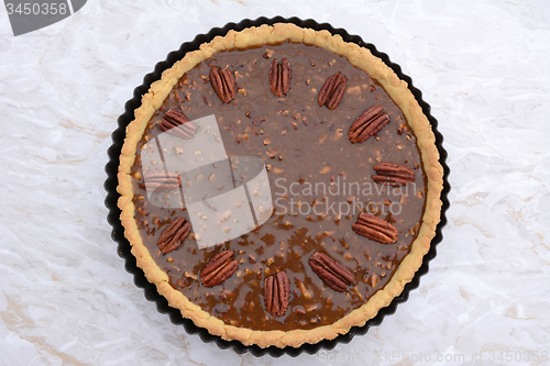 Image of Pecan pie decorated with nuts ready to be baked