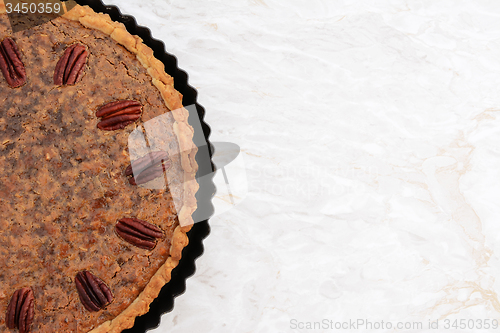 Image of Freshly baked pecan pie in the baking tin