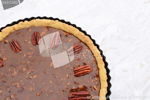 Image of Pecan nuts decorating the top of an unbaked pecan pie