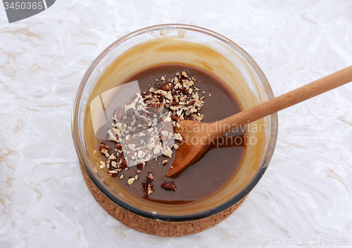 Image of Stirring chopped pecan nuts into filling for pecan pie