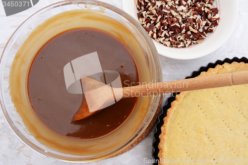 Image of Making pecan pie - stirring the filling with a wooden spoon