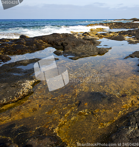 Image of beach  light  water   lanzarote foam rock spain    stone sky clo