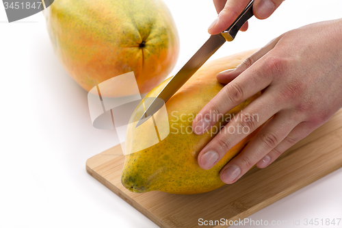 Image of Knife Positioned For A First Cut Through A Papaya