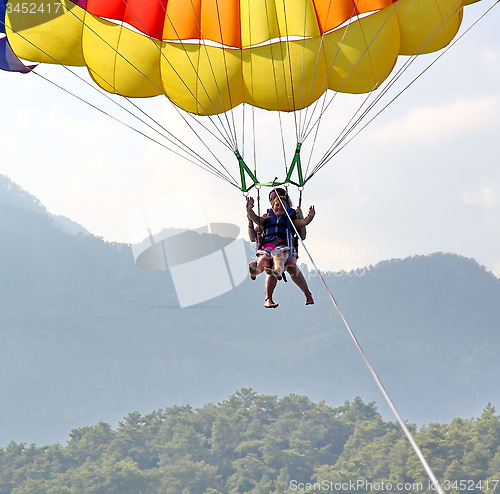 Image of Parasailing in a blue sky near sea beach