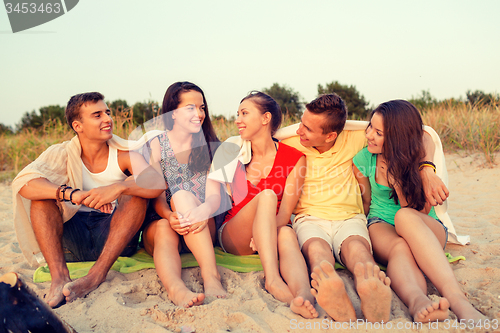 Image of smiling friends in sunglasses on summer beach
