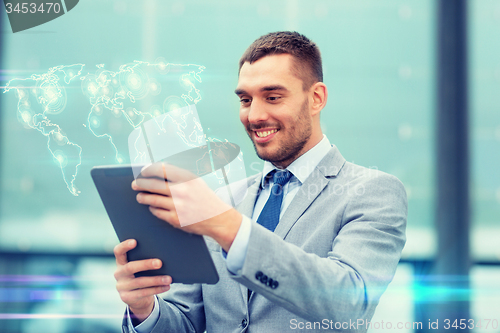 Image of smiling businessman with tablet pc outdoors