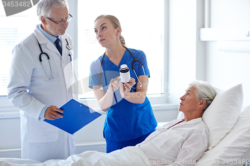 Image of doctor giving medicine to senior woman at hospital