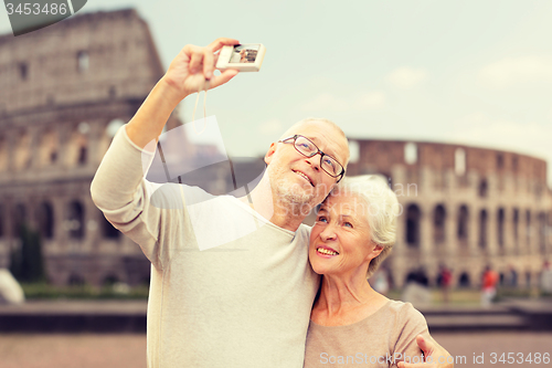 Image of senior couple photographing over coliseum