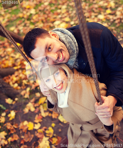 Image of smiling couple hugging in autumn park