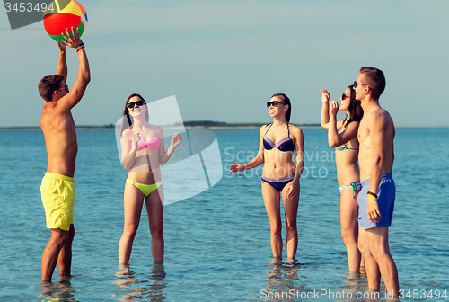 Image of smiling friends in sunglasses on summer beach